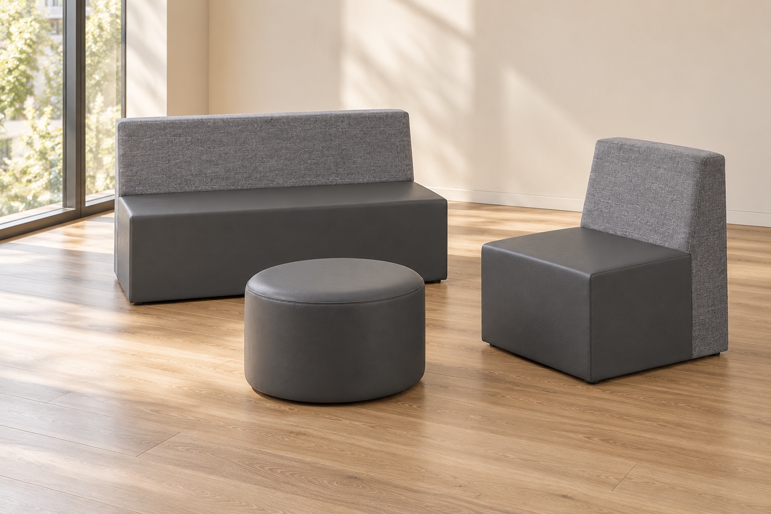 Gray Kolab two-seat and single lounge seating arranged with a round ottoman in a warm, sunlit reception room.